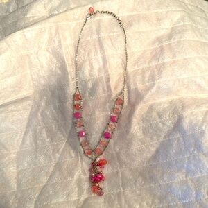 Hanging necklace w/clasp. Silver adjustable chain. Pink w/shades of pink beads.